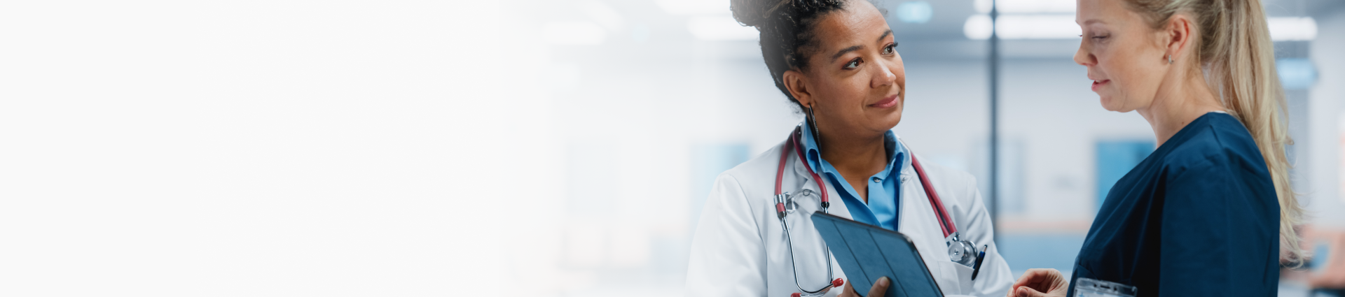 Two medical professionals in a clinic looking at a tablet.